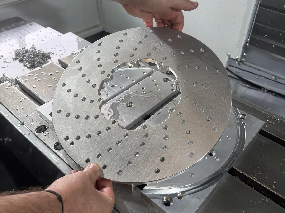 A clock disc, taken up by hand as it comes off the machine